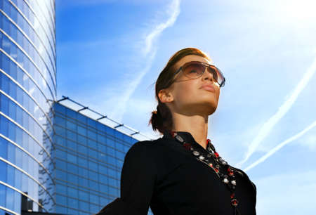 Beautiful young brunette. Modern building behind herの写真素材