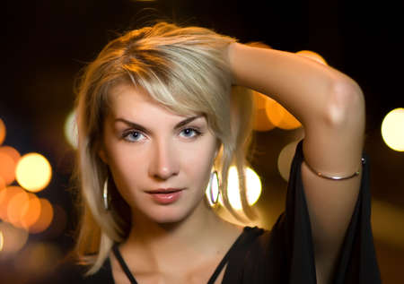 Beautiful young woman in a city at nightの写真素材