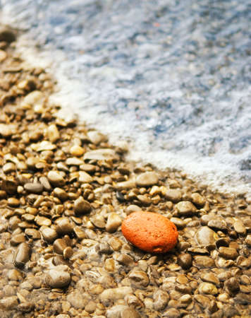 Ocean wave washes stone beachの写真素材