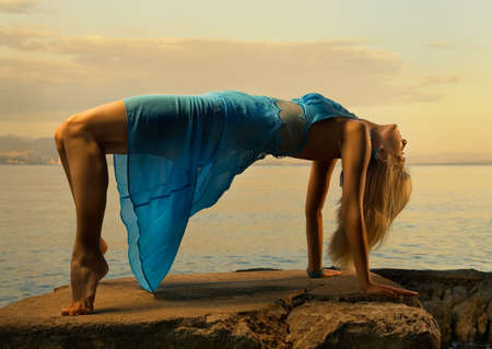 Sexy young woman standing in passionate pose near the ocean