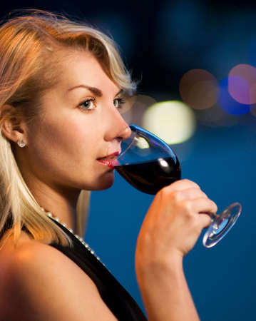 Beautiful young lady drinking red wine