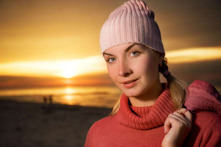 Young woman on a beach at sunset. Close-up portraitの写真素材