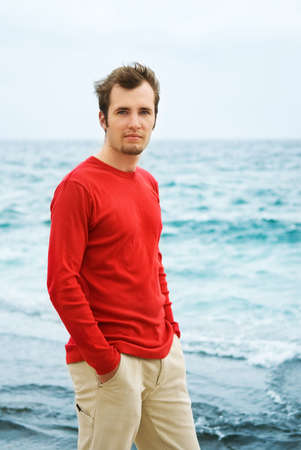 Handsome young man relaxing near the seaの写真素材