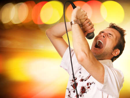 Young guy with a microphone over abstract background Young guy with a microphone over abstract background