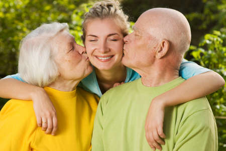 Grandparents kissing their granddaughterの写真素材