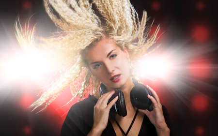 Beautiful young woman with headphones in nightclubの写真素材