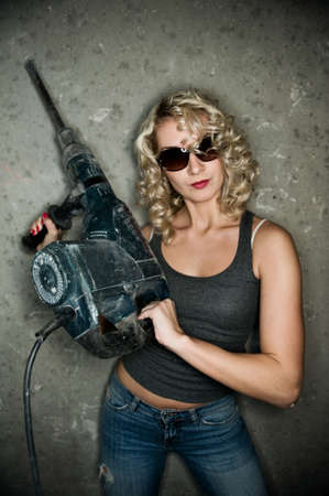 Beautiful blond woman with heavy perforator in her handsの写真素材