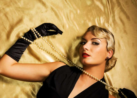 Lovely woman on golden fabric retro portraitの写真素材