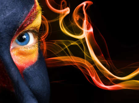 Portrait of a mysterious woman with artistic make-up on her face. Isolated on black backgroundの写真素材