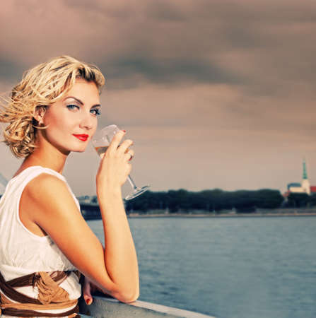 Beautiful blond girl drinks champagne near the river


の写真素材