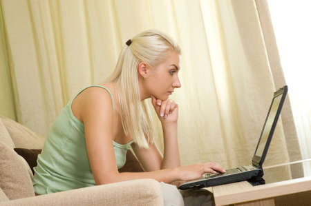 Young woman working on a laptop at home 

の写真素材