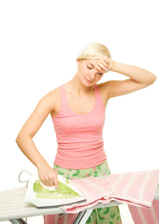 Beautiful young woman ironing clothesの写真素材