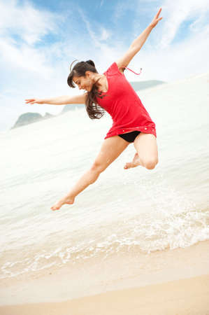 Beautiful young woman jumping in the sea 
の写真素材