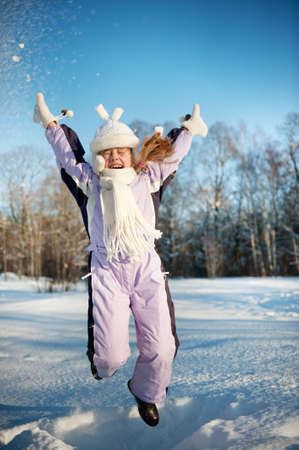 Happy girl jumping in the snowの写真素材