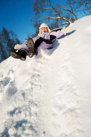Little girl sliding in the snowの写真素材