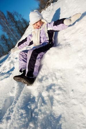 Little girl sliding in the snowの写真素材