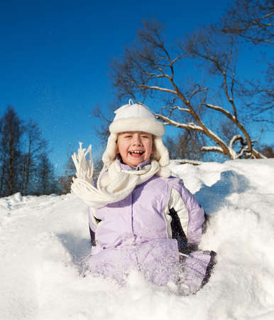 Little girl sliding in the snowの写真素材