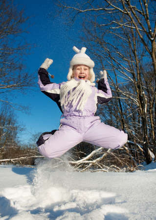 Happy girl jumping in the snowの写真素材