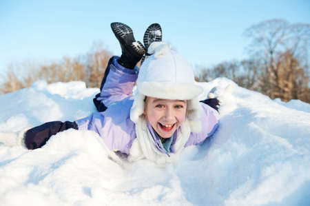 Little girl sliding in the snowの写真素材
