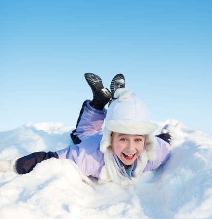 Little girl sliding in the snowの写真素材