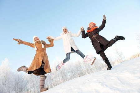 Happy girls jumping in the snow