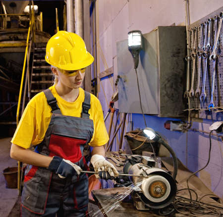 Factory female worker sharpening tools 

