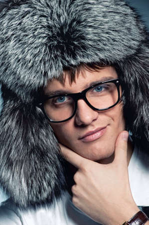 Portrait of handsome young man wearing fluffy hatの写真素材