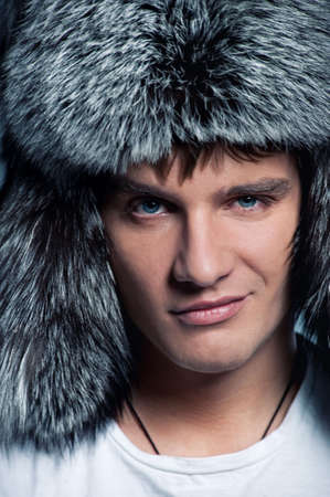 Portrait of handsome young man wearing fluffy hatの写真素材