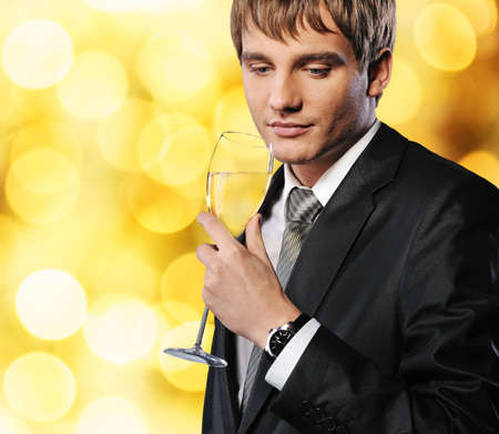 Businessman with a glass of champagne over abstract backgroundの写真素材