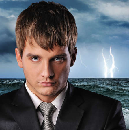 Portrait of a serious businessman over dark stormy sky
