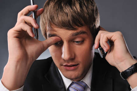 Thinking businessman talking on mobile phoneの写真素材