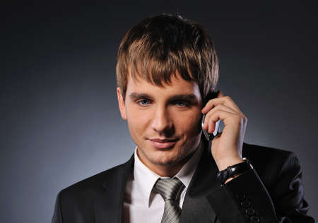  Handsome young businessman talking on mobile phone の写真素材