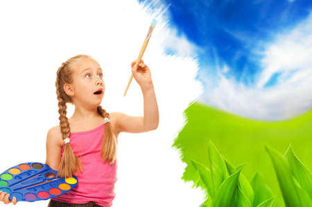 Beautiful little girl painting nature landscapeの写真素材