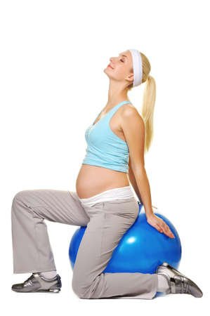 Young pregnant woman making exercise on a fitness ball の写真素材