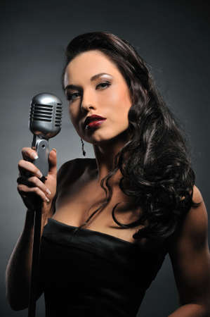  Portrait of a beautiful brunette with a retro microphone 
の写真素材