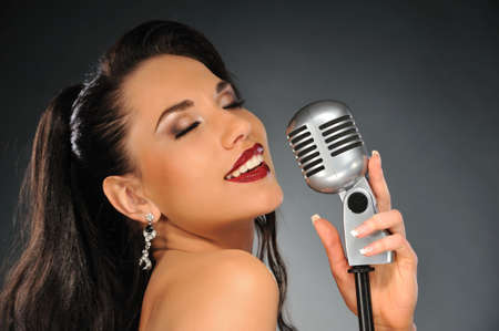 Portrait of a beautiful brunette with a retro microphone 
の写真素材