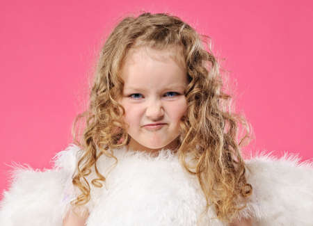 Little angel girl making funny faceの写真素材