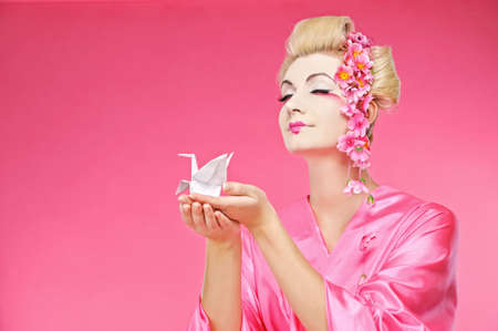 Beautiful geisha holding origami bird の写真素材