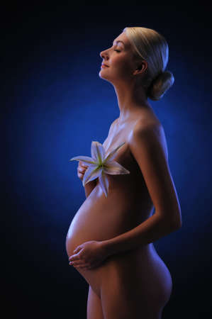 Beautiful pregnant woman with a lily flowerの写真素材