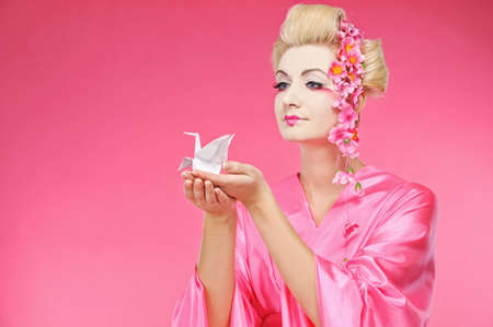 Beautiful geisha holding origami birdの写真素材