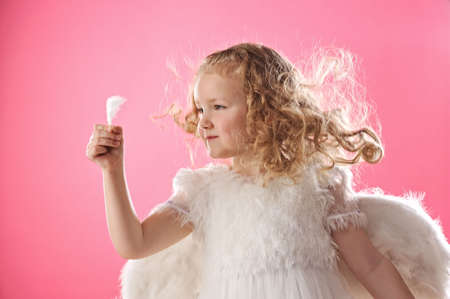  Beautiful angel girl holding a feather 
の写真素材