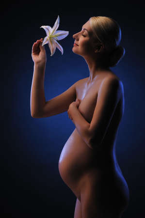 Beautiful pregnant woman with a lily flowerの写真素材