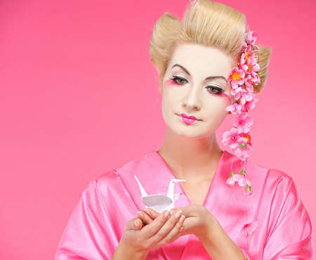 Beautiful geisha holding origami birdの写真素材