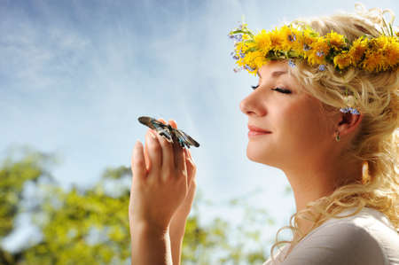 Lovely woman with a butterfly over blue skyの写真素材