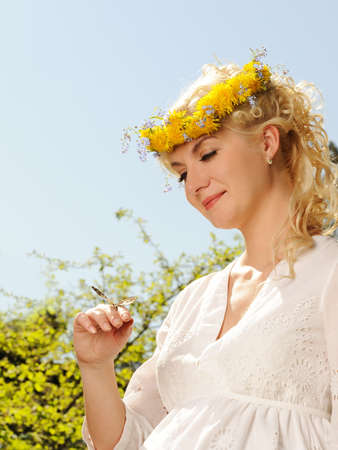 Lovely woman with a butterfly over blue skyの写真素材