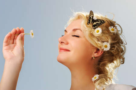 Lovely woman with a butterfly over blue skyの写真素材