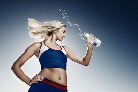 Young woman drinking water after fitness exerciseの写真素材