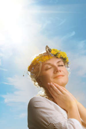 Lovely woman with a butterfly over blue skyの写真素材
