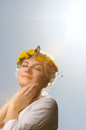 Lovely woman with a butterfly over blue skyの写真素材