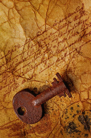 The old key on the textured paperの写真素材